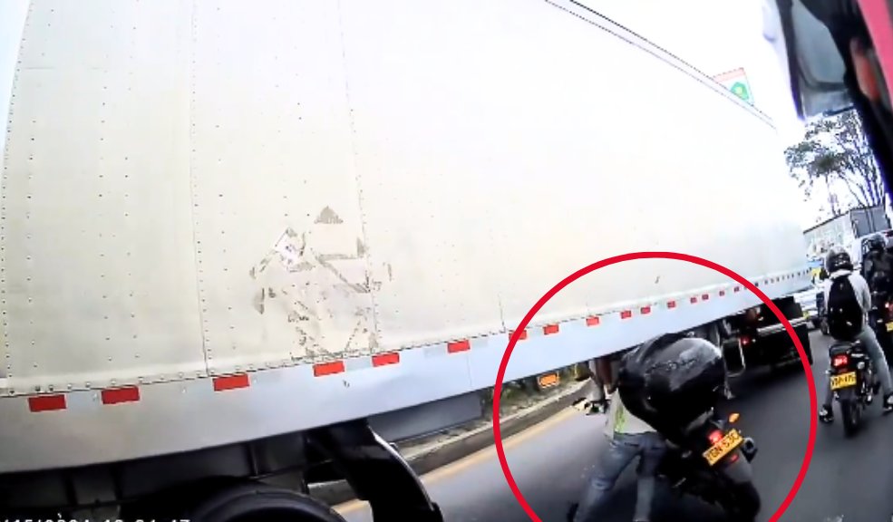 Imprudente motociclista intentó pasar por debajo de una tractomula para evitar trancón El motociclista fue grabado cuando intentaba pasar por debajo de una tractomula.